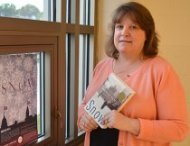 Denise Beasley, an English teacher at Osseo-Fairchild High School who is shown holding a copy of Snow by Orhan Pamuk, has utilized the Great World Texts program for five years.